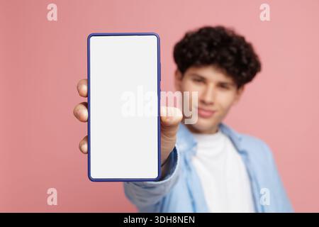 Close up of young man holding smartphone with empty white screen for app interface promo, online service ads and UI design Stock Photo