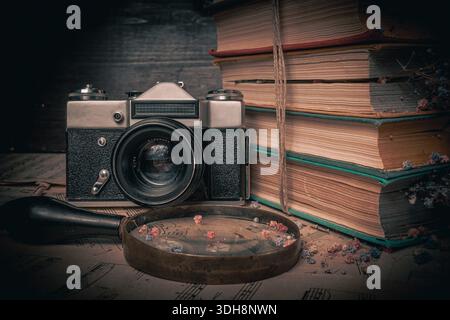 Old aged film camera in black leather cases photography close-up. Vintage camera on black wooden background Stock Photo