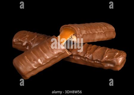 Three chocolate bars with one of them cut in half. The bars are stacked on top of each other Stock Photo