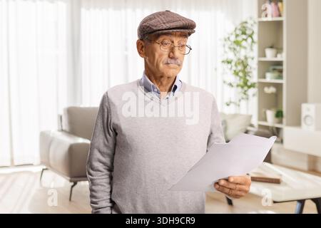 Confused senior man reading a document at home Stock Photo