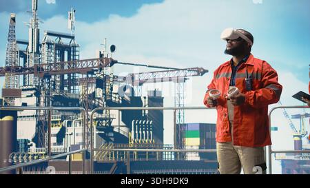 Offshore platform expert supervising deck operations using virtual reality technology. Man working for gas company doing preventative maintenance on drilling rig using VR goggles, Stock Photo