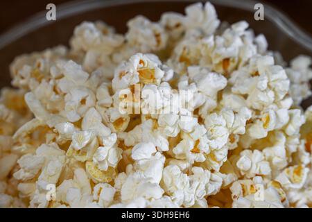 A close up view of the texture of freshly popped microwave popcorn in a clear bowl. Stock Photo