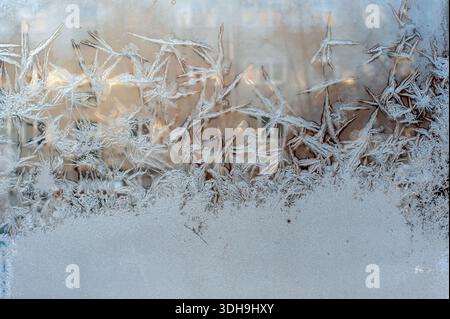 Frosty patterns on the window glass. The patterns look like swan feathers. Abstract natural texture in winter. Stock Photo