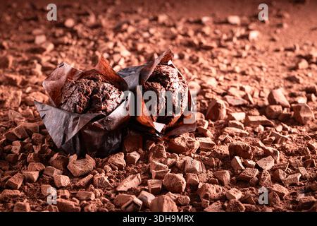 Dark chocolate muffins made of dark chocolate and cocoa. Muffins on chocolate and cocoa background. Stock Photo