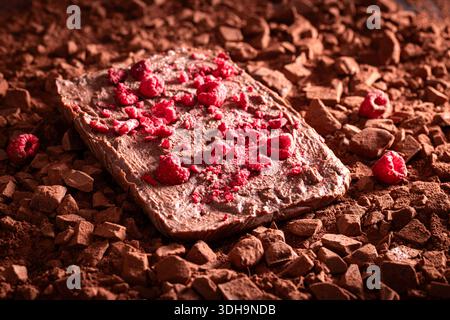 Handmade raspberry chocolate on cocoa and chopped dark chocolate. Raspberry chocolate on cocoa background. Stock Photo