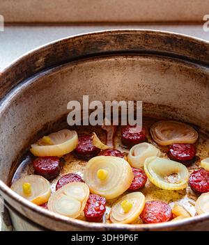Roasted onion rings and chorizo in a vintage pan Stock Photo