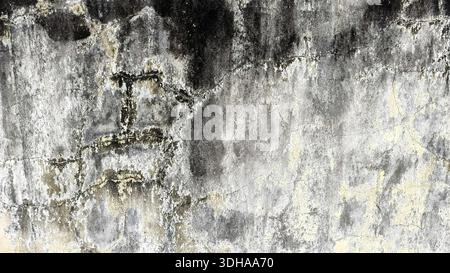 A close-up shot of a heavily weathered wall with visible cracks, peeling beige paint, and dark mold stains, creating a gritty, aged industrial texture Stock Photo