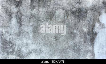 High-resolution close-up of a weathered, grey concrete wall with dark stains, fine grain texture, and signs of aging, ideal for backgrounds and overla Stock Photo