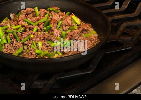 Close-Up of Ground Beef and Chopped Asparagus Cooking in Hot Skillet Stock Photo