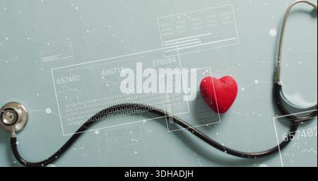 Displaying stethoscope and red heart model lying on matte teal table, with HUD overlays Stock Photo