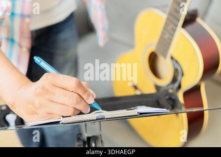 Close up of young man composing music at home. Songwriter having fun enjoy hobby concept. Selective focus on hand. Stock Photo