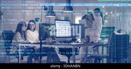 Team of female programmers working in office at night Stock Photo