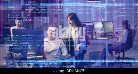 Team of programmers working in office at night Stock Photo