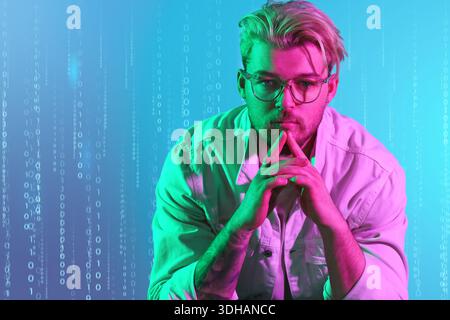 Toned portrait of handsome young man against color background with digital code Stock Photo
