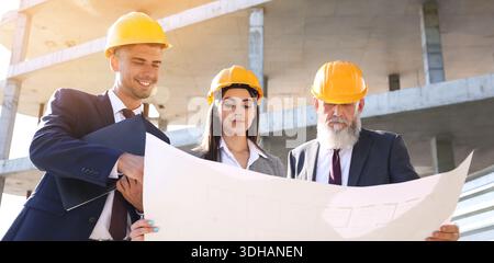 Architects discussing project of building outdoors Stock Photo