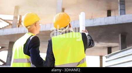 Engineers discussing project of building outdoors Stock Photo