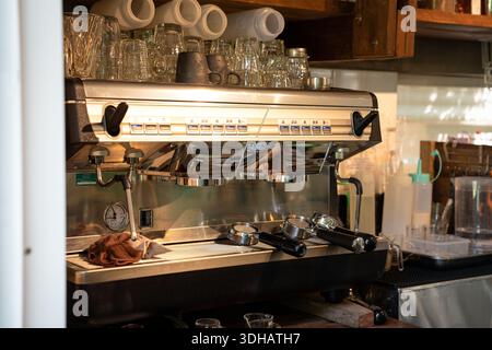Luxury automatic coffee machine with bottomless portafilter and glass on counter in coffee shop Stock Photo