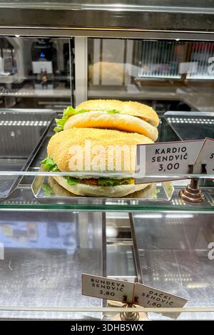 Classic fast food sandwich burger with meat, vegetables, bread on tray in dining room Stock Photo