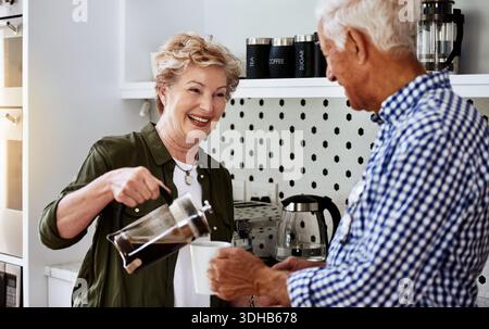 Pouring, coffee and old couple in kitchen, laughing and happy to start day with fresh warm beverage. Morning, routine and old people with plunger for Stock Photo