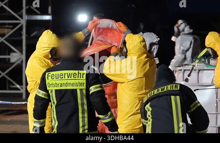 PRODUCTION - 16 January 2026, Lower Saxony, Papenburg: Firefighters help a police officer out of a hazmat suit. In a crackdown on organized crime, emergency services have smashed laboratories and seized tons of chemicals and drugs in several European countries in Europe's largest synthetic drug investigation complex. Photo: Lars Penning/dpa - ATTENTION: Person(s) has/have been pixelated for legal reasons Stock Photo