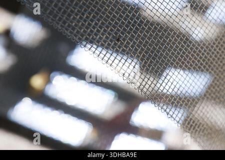 Detail shot showing texture of window screen mesh with abstract background light, creates sense of protection, safety and isolation looking out from i Stock Photo
