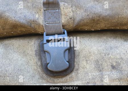 Close up detail of dirty old buckle strap grunge canvas bag surface showing sturdy rugged texture and tough resilient character evoking feeling of adv Stock Photo