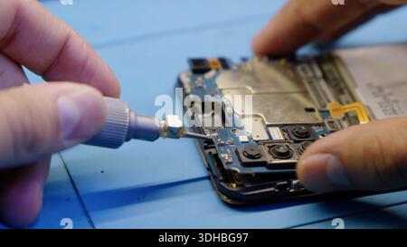Close up of hands repairing a broken smartphone screen Stock Photo