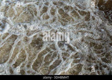 Frothy patterns in river water Stock Photo