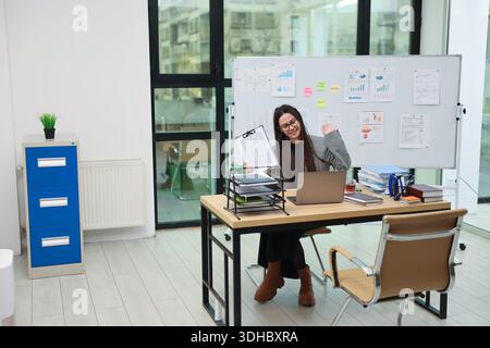 Professional woman working in a modern office, engaging in virtual meetings and collaborating on projects Stock Photo