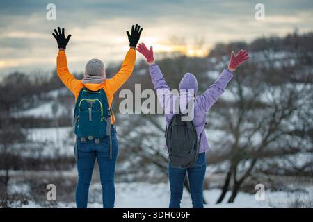 Two people celebrating winter hiking success outdoors Stock Photo