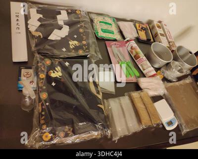 Baking supplies and tools laid out on a table, including mixing bowls, utensils, measuring devices, and packaged ingredients. Stock Photo