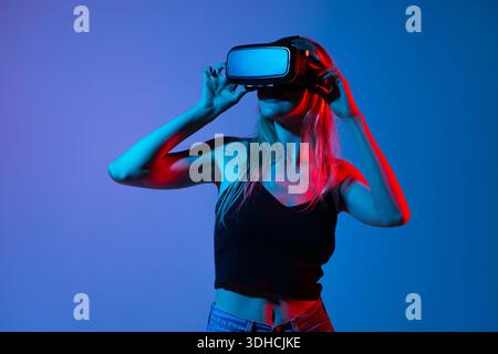 Woman interacting with virtual reality interface using hand gestures, metaverse and immersive technology concept Stock Photo