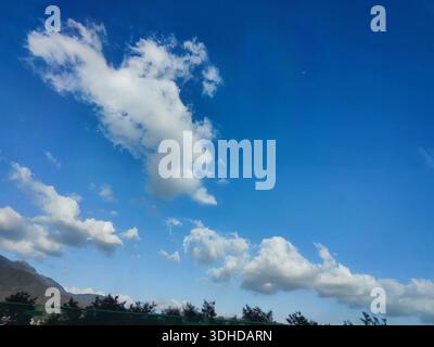 Dramatic Clouds Against a Vibrant Blue Sky with Mountain Silhouette Stock Photo