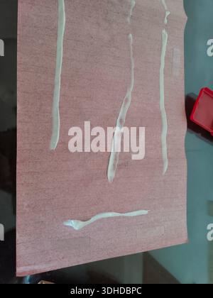 White adhesive lines on pink textured paper surface Stock Photo