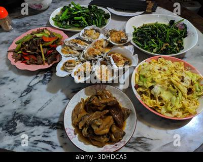 A lavish Chinese family dinner featuring multiple traditional dishes on a marble table Stock Photo