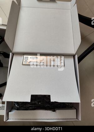 Open white box containing a metal motherboard bracket and internal components Stock Photo