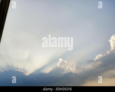 Sunlight Breaking Through Clouds at Sunset Stock Photo