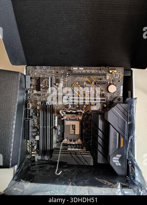 New motherboard with CPU socket and cooling shroud inside packaging box Stock Photo