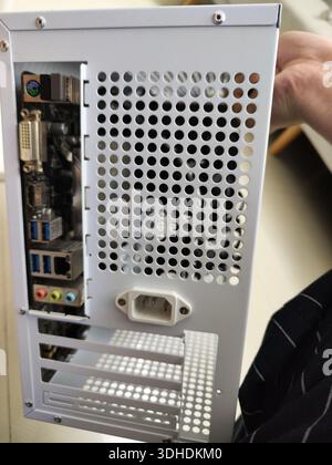 Close-up of a computer case rear panel with ports and ventilation holes Stock Photo