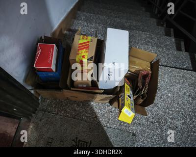 Piled cardboard boxes and packaging materials on staircase landing Stock Photo