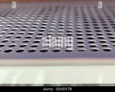 Close-up of perforated metal sheet with circular holes, industrial texture Stock Photo
