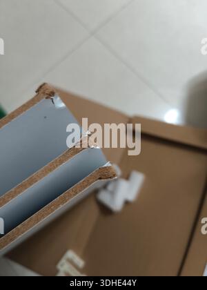 Close-up of damaged cardboard box with torn edges and exposed foam insulation Stock Photo