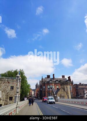Historic Bridge with Stone Architecture and Red Brick Buildings Under Blue Sky Stock Photo