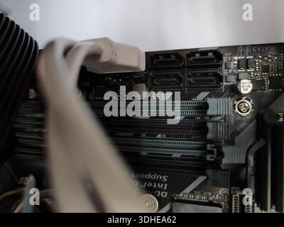 Close-up of computer motherboard with RAM slots and cable connection Stock Photo