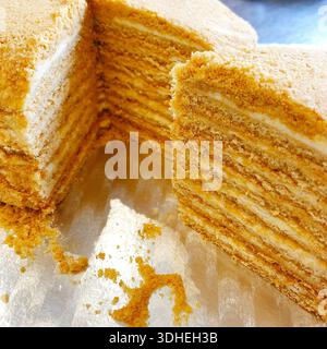 Close-up of layered honey cake with creamy filling, showing intricate texture and golden layers Stock Photo