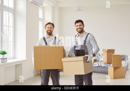 Professional movers carrying cardboard boxes during home relocation and delivery Stock Photo