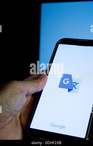 Smartphone screen showing google translate app icon, symbolizing instant multilingual translation, ai-powered language tools, and seamless global comm Stock Photo