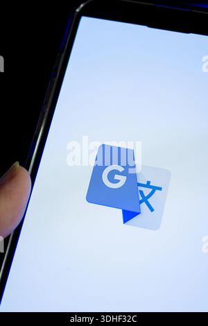 Smartphone screen showing google translate app icon, symbolizing instant multilingual translation, ai-powered language tools Stock Photo