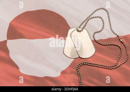 Metal military dog tags placed on Greenland flag background Stock Photo