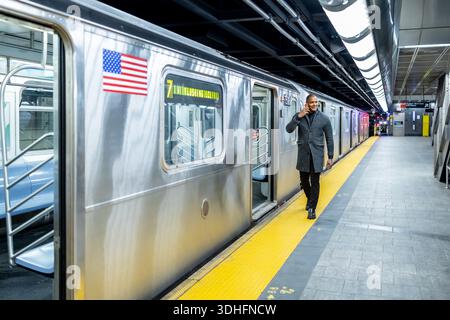 Professional businessman talking on phone leaving subway train Stock Photo